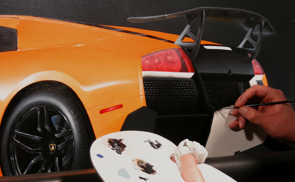 Darrell White's hand painting the rear fender and taillight of an orange Lamborghini Murcielago